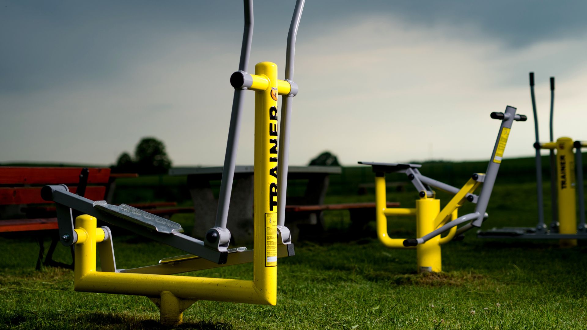 Appareils de fitness extérieur de type vélo elliptique et skieur de fond installés sur un terrain engazonné