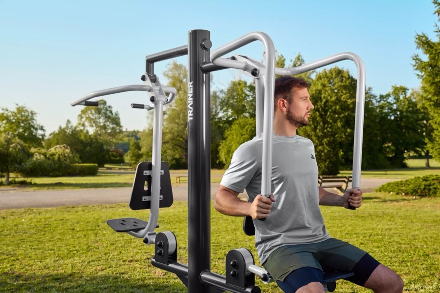 Homme utilisant une presse à pectoraux de fitness extérieur dans un parc